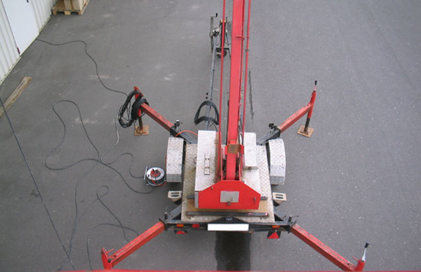 Eine rote Arbeitsbühne auf Asphalt, bereit für Elektroarbeiten in der Höhe durch Elektro Bohr.