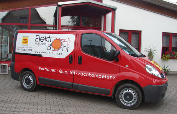 Ein roter Firmenwagen von Elektro Bohr mit Kontaktdaten und Slogan "Vertrauen · Qualität · Fachkompetenz" in saalfeld.